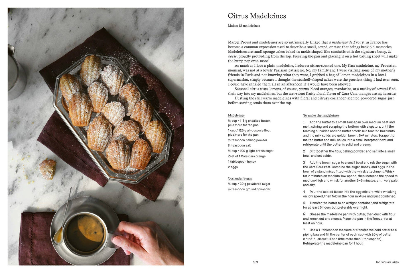 Madeleines on a tray with a cup of tea and a recipe for Citrus Madeleines on a marble surface.