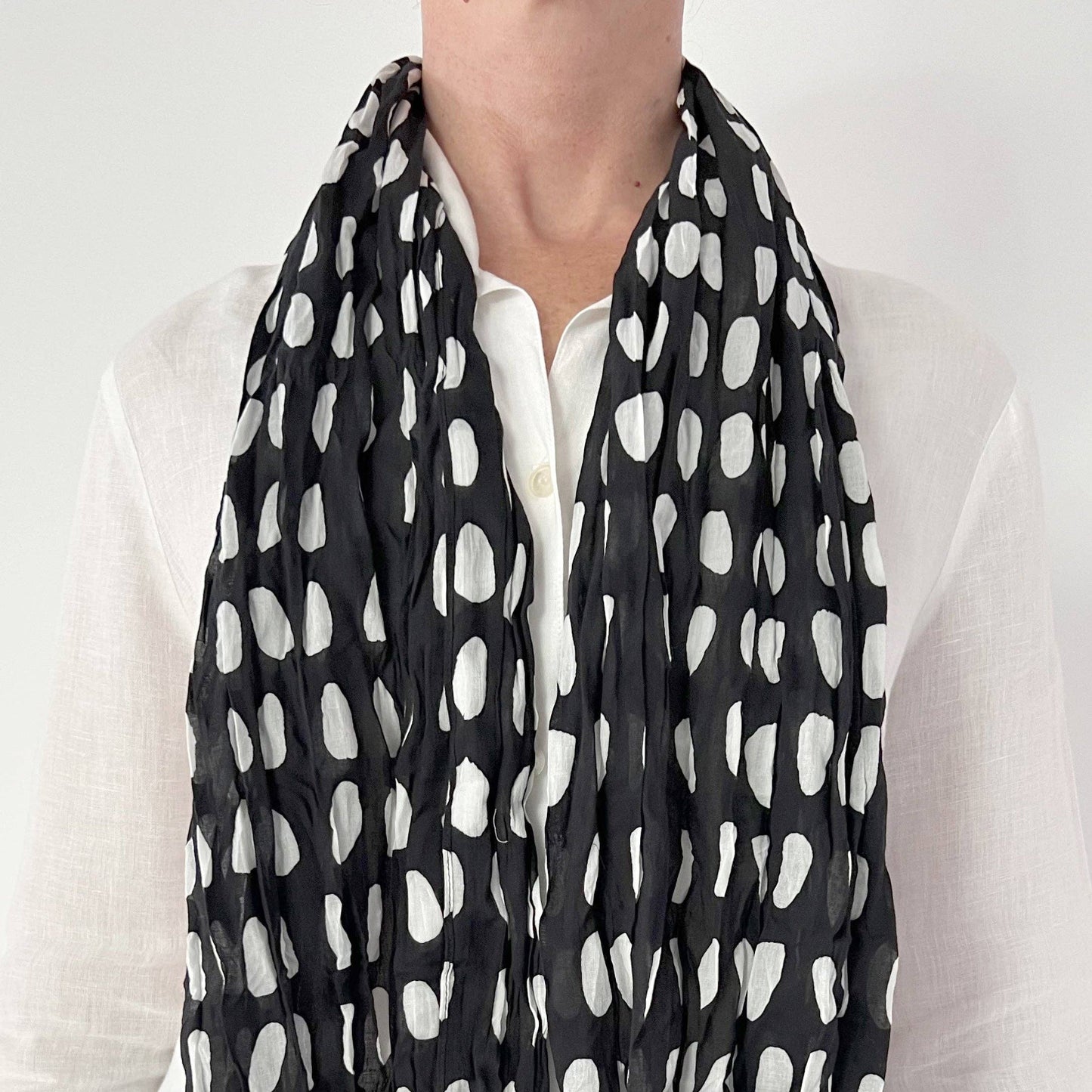 Person wearing a black and white polka dot scarf