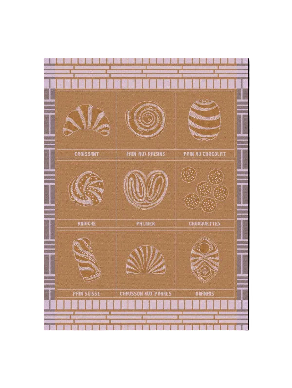 A towel featuring nine illustrated French pastries arranged in a tan background, with a lavender and beige patterned border. The illustrations are rendered in a light cream or off-white tone, with the names of the pastries printed below each drawing.