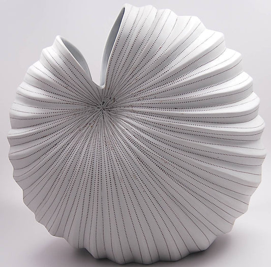 White decorative pillow with a textured, fan-like design on a light gray background