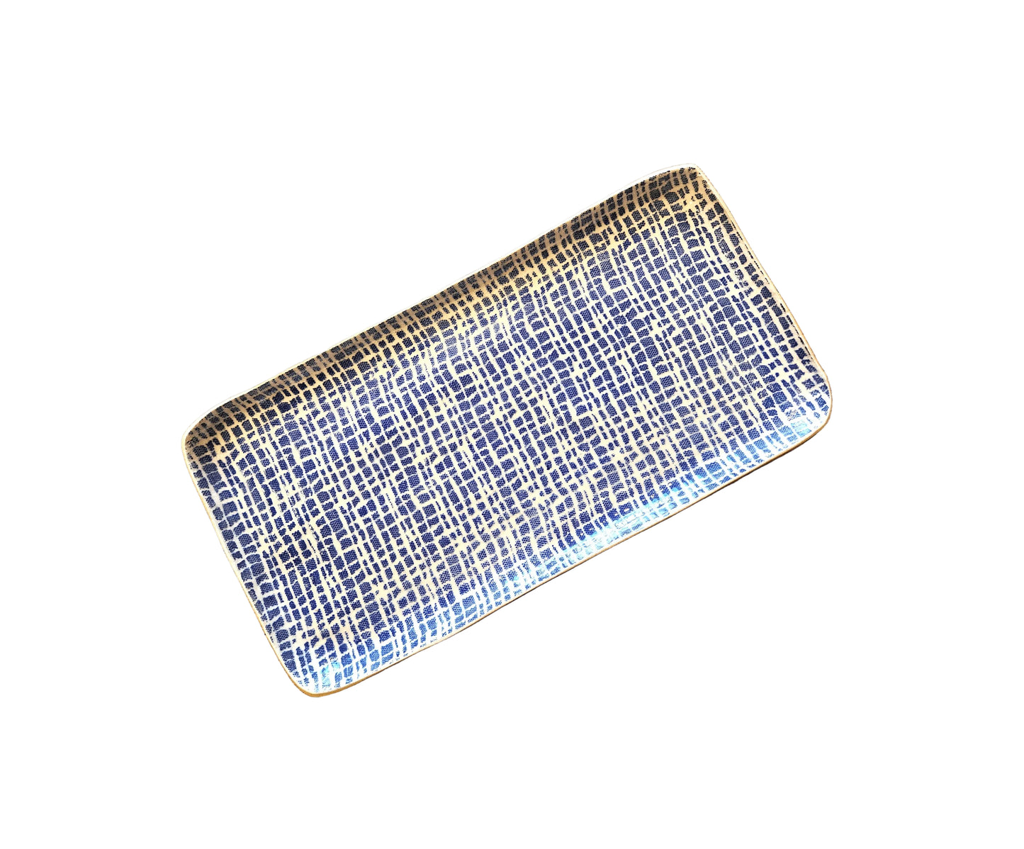 A rectangular ceramic serving platter with a blue and white grid pattern and gold accents, displayed diagonally on a rustic wooden surface.