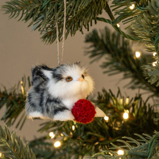 A small plush small kitten ornament with gray, white, and black fur hanging from a string o