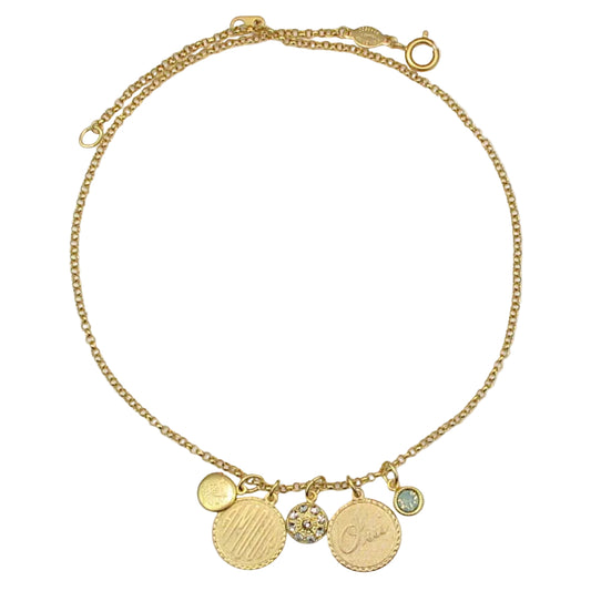 Gold necklace with various charms on a light gray background