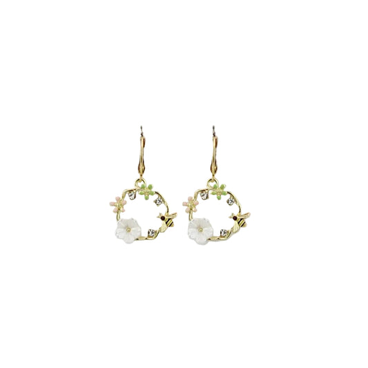 Pair of gold earrings with floral designs on a light gray background
