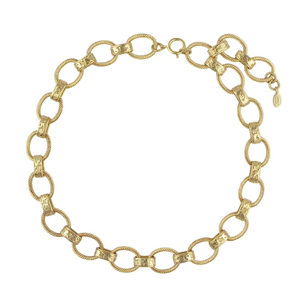Gold chain necklace on a light gray background