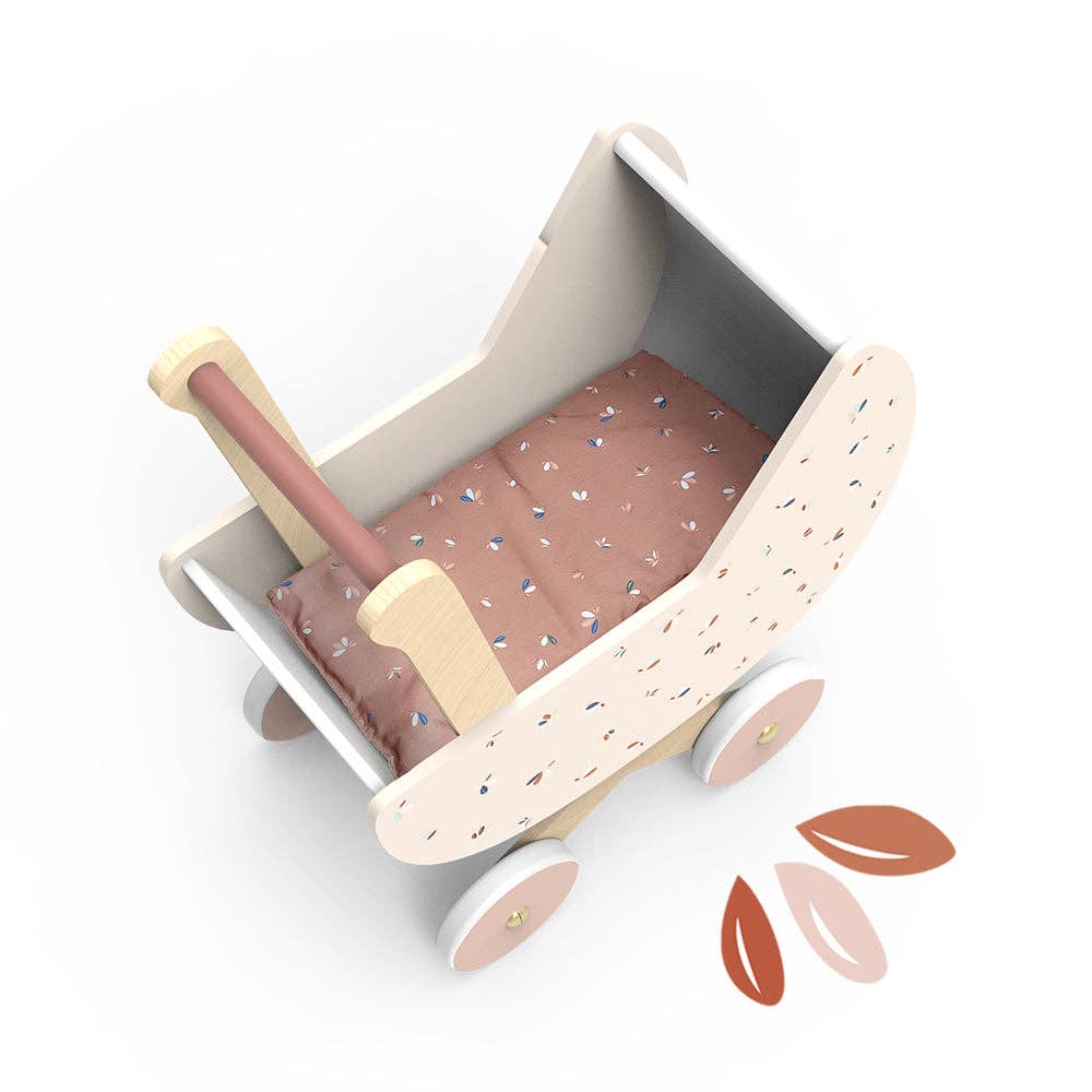 Wooden toy bed with pink bedding on a white background