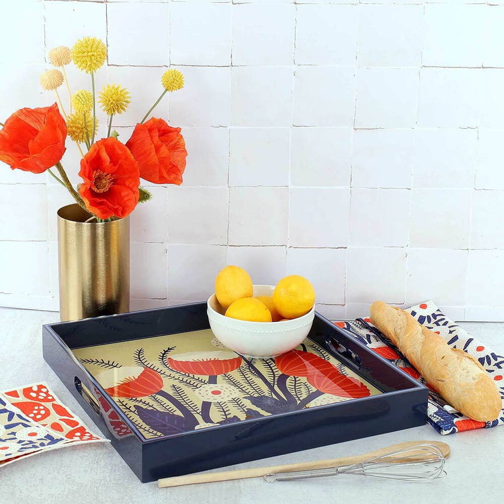 Decorative tray with floral design, lemons, and bread on a white surface.