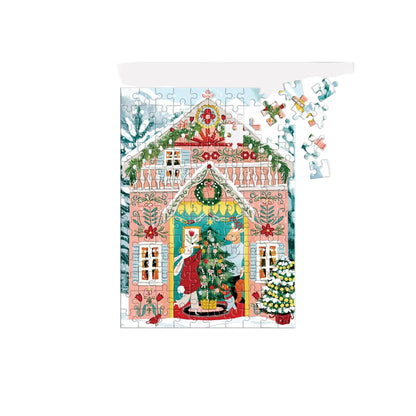 A completed and partially assembled jigsaw puzzle showing a festive Christmas house scene with Santa, a decorated tree, snow, and holiday garlands, on a light gray background.