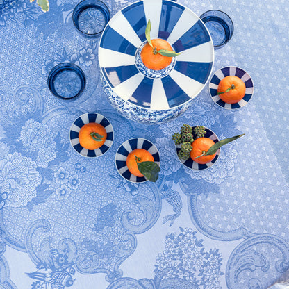 Blue and white patterned tablecloth with decorative plates and oranges.