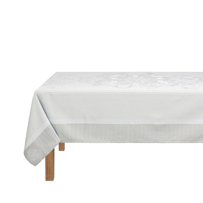White tablecloth with subtle pattern on a wooden table against a white background