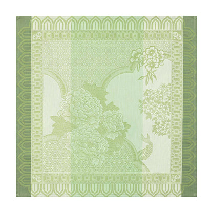 Decorative green napkin with floral and geometric patterns on a white background