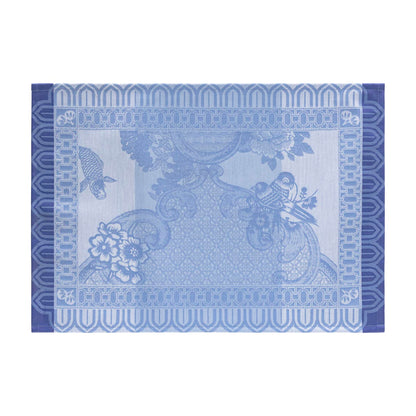 Decorative blue placemat with floral and paisley patterns on a white background