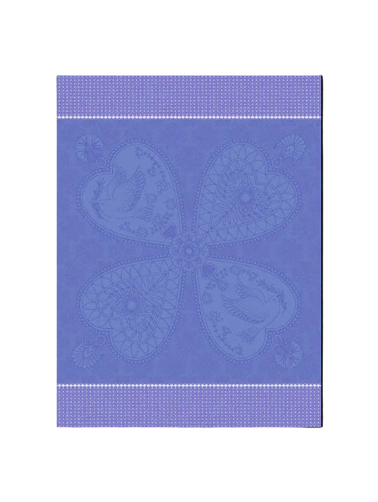 A square fabric or textile swatch in periwinkle blue with a tonal, raised floral pattern. The design features a central quatrefoil motif composed of four heart-shaped sections with birds and floral details, framed by horizontal dotted borders at the top and bottom.