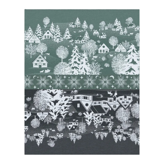 A close-up of a patterned fabric or wallpaper featuring a winter village scene with white houses, trees, and decorative floral bands on dark green and charcoal backgrounds.